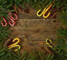 Noël arbre branche avec cônes, cannelle, dittany et bonbons canne sur en bois Contexte avec fond photo