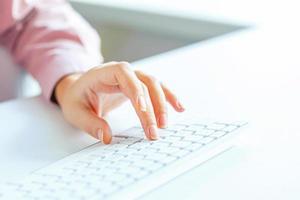 femme Bureau ouvrier dactylographie sur le clavier photo