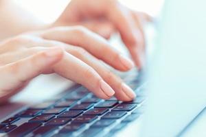 mains féminines ou employée de bureau tapant sur le clavier photo