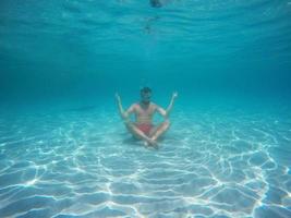 barbe homme avec des lunettes dans le lotus position méditer en dessous de l'eau photo