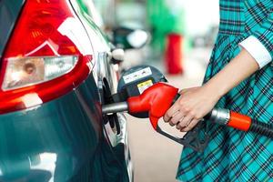 femme remplit essence dans le voiture à une gaz station photo