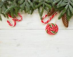 Noël frontière avec sapin arbre branches avec cônes et bonbons canne sur blanc en bois planches photo