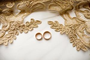 paire de d'or mariage anneaux plus de voile avec dentelle. mariage accessoires. sélectif concentrer photo