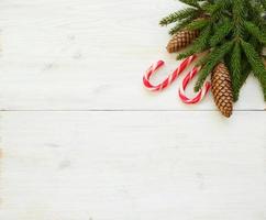Noël frontière avec sapin arbre branches avec cônes et bonbons canne sur blanc en bois planches photo
