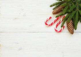 Noël frontière avec sapin arbre branches avec cônes et bonbons canne sur blanc en bois planches photo