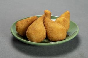 traditionnel frit coxinha dans assiette sur ardoise arrière-plan, populaire brésilien casse-croûte photo