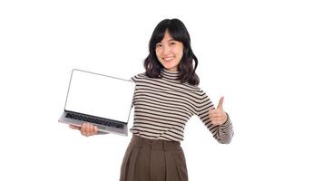 magnifique Jeune asiatique femme sur chandail tissu en portant portable PC ordinateur et à la recherche à caméra avec sourire visage et pouce en haut, isolé sur blanc Contexte photo