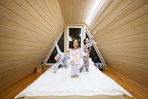 les enfants dans doux chaud pyjamas en jouant à en bois cabine maison. concept de enfance, loisir activité, Bonheur. frère et sœurs ayant amusement et en jouant ensemble. photo