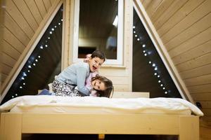 les enfants dans doux chaud pyjamas en jouant à en bois cabine maison. concept de enfance, loisir activité, Bonheur. frère et sœur ayant amusement et en jouant ensemble. photo