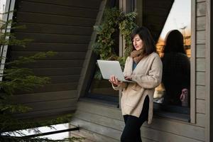 éloigné travail et s'échapper à la nature concept. femme travaux sur portable contre minuscule cabine maison. photo