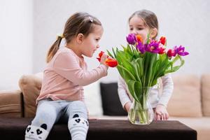 deux sœurs avec printemps tulipe bouquet. vacances décor avec fleurs coloré tulipes. photo