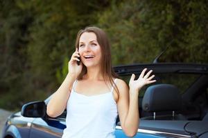 souriant femme parlant sur téléphone dans une cabriolet voiture photo