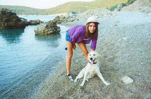 femme avec une chien sur une marcher sur le plage photo