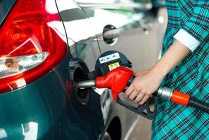 femme remplit essence dans le voiture à une gaz station photo