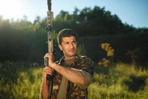 homme de arabe nationalité dans camouflage avec une fusil à pompe photo