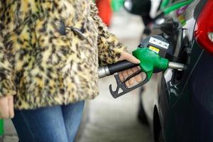 femme remplit essence dans sa voiture à une gaz station dans hiver photo