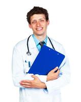 portrait de une souriant Masculin médecin en portant une bloc-notes sur blanc photo