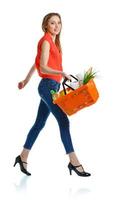 content femme en portant une panier plein de en bonne santé aliments. achats photo