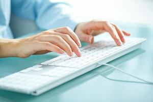 femme Bureau ouvrier dactylographie sur le clavier photo