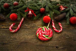 bordure de Noël avec des branches de sapin, des cônes, des décorations de Noël et des cannes de bonbon sur des planches en bois rustiques photo