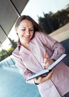 Jeune femme d'affaires avec téléphone portable et organisateur photo