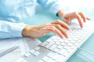 femme Bureau ouvrier dactylographie sur le clavier photo