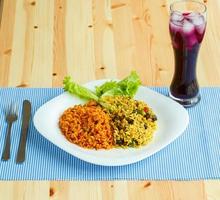 délicieux plat fabriqué de deux sortes de riz sur une blanc assiette et une verre de jus avec la glace photo