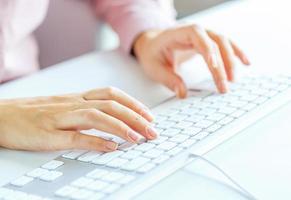 femme Bureau ouvrier dactylographie sur le clavier photo