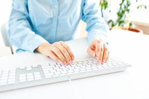 femme Bureau ouvrier dactylographie sur le clavier photo