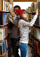 Jeune couple à le bibliothèque photo