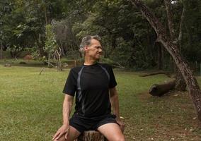 mature homme à l'extérieur à une local parc Faire s'étire avant travail en dehors photo