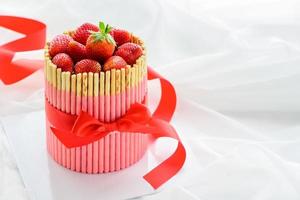 Frais fraise gâteau avec fraise biscuit des bâtons et rouge ruban photo