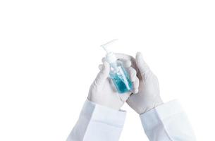 médecins main est portant caoutchouc gants, en portant une bouteille de de l'alcool gel isolé sur blanc Contexte photo