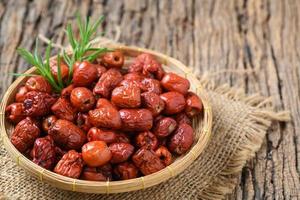 séché jujube, chinois séché rouge Date fruit dans bambou panier sur vieux bois arrière-plan, photo