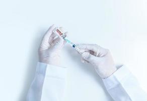 médecin ou scientifique main dans blanc gants en portant grippe, rougeole, coronavirus vaccin coup pour maladies déclenchement vaccination sur blanc arrière-plan, photo