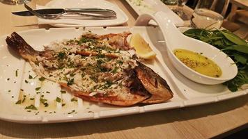 frit poisson sur une blanc plaque, saupoudré avec assaisonnements. photo