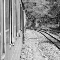 petit train se déplaçant sur les pentes de la montagne, belle vue, un côté montagne, un côté vallée se déplaçant sur le chemin de fer jusqu'à la colline, parmi la forêt naturelle verdoyante. train jouet de kalka à shimla en inde, train indien photo