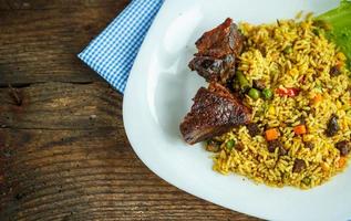 plat de rôti du boeuf avec riz et salade feuilles photo