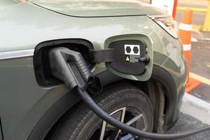 ev voiture ou électrique voiture à mise en charge station avec le Puissance câble la fourniture branché. ev mise en charge station pour électrique voiture dans concept de vert énergie et éco Puissance produit. photo