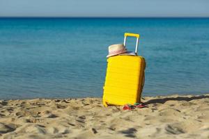Voyage vacances vacances valise avec carte, paille chapeau et plage chaussons sur le le sable plage