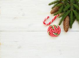 Noël frontière avec sapin arbre branches avec cônes et bonbons canne sur blanc en bois planches prêt photo