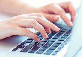 mains féminines ou employée de bureau tapant sur le clavier photo