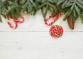 Noël frontière avec sapin arbre branches avec cônes et bonbons canne sur blanc en bois planches photo