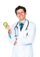 portrait de une souriant Masculin médecin en portant vert Pomme sur blanc photo