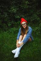 magnifique fille posant contre le toile de fond de le vert herbe et des arbres photo