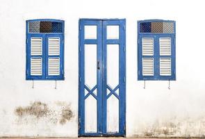 bleu en bois porte et fenêtre sur vieux blanc mur Contexte photo