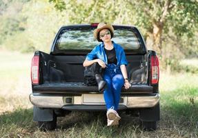 femme portant un chapeau et portant son sac de guitare sur une camionnette photo