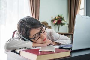 Adolescente cheveux courts dormir sur le bureau après avoir travaillé photo