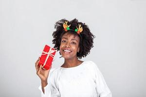 proche en haut portrait de attrayant magnifique fille en portant cadeau boîte dans mains heureux prêt à déballer il portant décontractée chemise isolé sur blanc Contexte photo