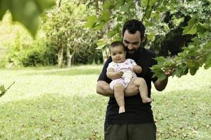 père en portant bébé fille entouré par la nature. photo